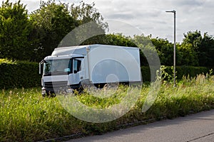 White rigid lorry with white box trailer travelling on the dual carriageway