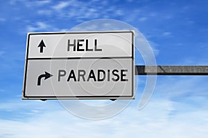 White road sign with words hell and paradise against blue sky background