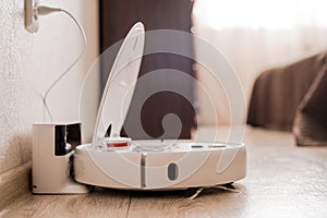 White robot vacuum cleaner on the floor in interior