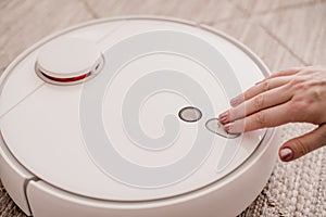 White robot vacuum cleaner on the floor in interior