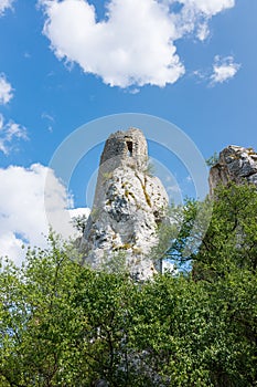 White rock in forest, national park, green trees, blue sky with clouds