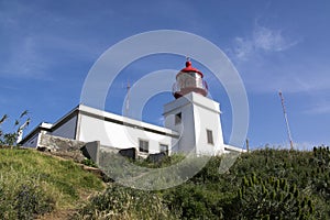 White romantic lighthouse on the cliff, west Madeira island, village Ponta do Pargo, Portugal, Atlantic ocean