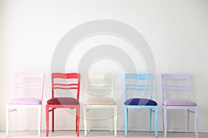 White room with colorful chairs blue yellow red blue purple