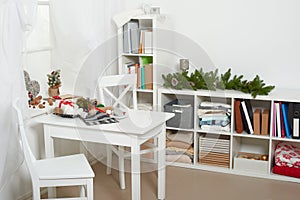 White room interior with christmas decoration, window, table and chair