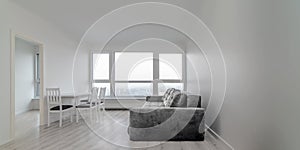 White room with table, chairs and sofa