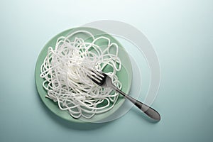 White rope with a fork on a round plate. Spaghetti concept