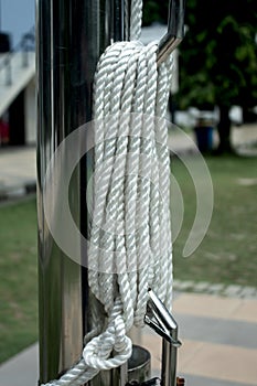 white rope neatly tied to an iron pole