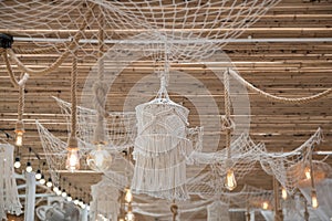 White rope thread net and cage on bamboo ceiling with light bulb