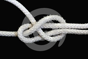 A white rope tied with sheet bend knot on black background