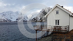 White Rorbu cottage and Reinefjorden from Toppoy island on the Lofoten in Norway in winter