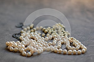 White rosary and pearl necklace on linen fabric