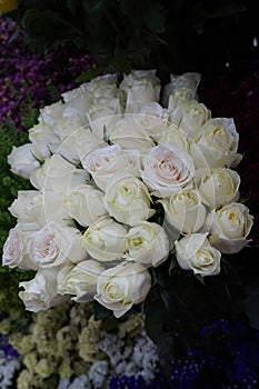 White Roses Background. Variety of white roses in beautiful bouquet. Bridal bouquet of white rose in bright colors in flower shop