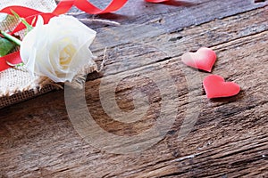 White roses and red satin hearts on vintage wooden background for Valentine& x27;s concept