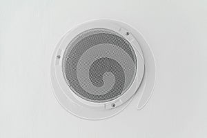 White round circle speaker and grille hanging on ceiling