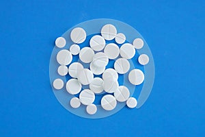 White round pills on a blue background.