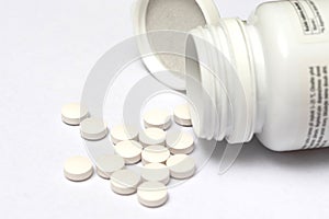 White round pills spilling form its bottle