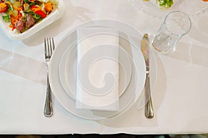 White round plate with serving napkin on table.