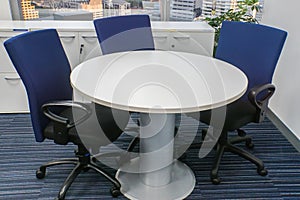 White round table with blue chairs for office meeting