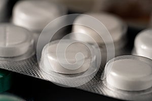 White round tablets in a blister pack. Close up of medicinal pills. Vitamins, antibiotics, painkiller pharmaceuticals