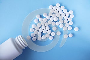 White round tablets, supplements with a can on a blue background. Magnesium vitamins