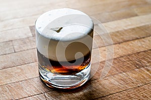 White Russian Cocktail on wooden surface.
