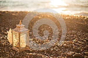 White rustic lantern on the pebble beach