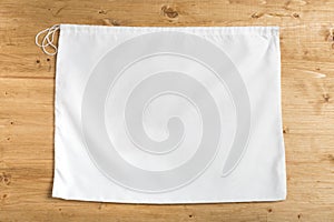 White sack bag on strings on wooden background, mock up photo