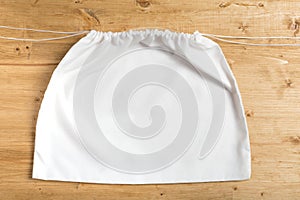 White sack bag on strings on wooden background, mock up photo