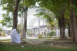 White sacks are used to contain dead leaves that have fallen seasonally in spring as way to clean park and mix leaves to make