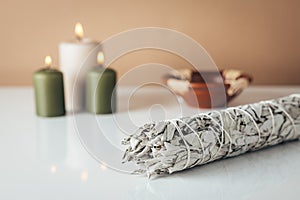 White sage and burning candles in background