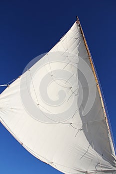 White sail of a sailboat in the sky