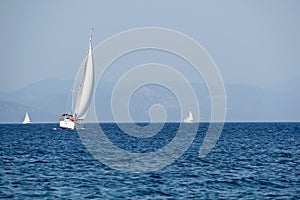 White sailboat against the blue of the sea and the sky