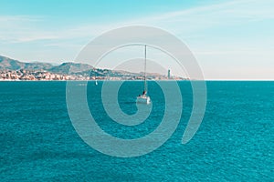 White sailboat sailing in the ocean under the blue sky