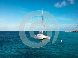 White sailing boat catamaran on ocean near beach