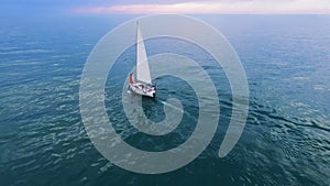 White sailing boat with couple at sea, romantic cruising leisure, freedom