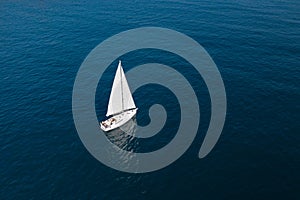 White sailing yacht in the blue sea top view