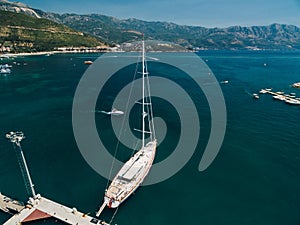 White sailing yacht on the pier near the city of Budva Montenegro against the backdrop of mountains