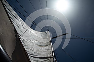White sails against blue sky and summer sun