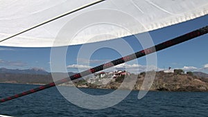 White sails and rope on sailing boat details on deck of moving sailing yacht.