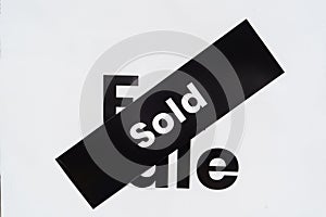 White for sale sign near the resedential appartment building with sold sticker on it. Real estate property investment boom concept