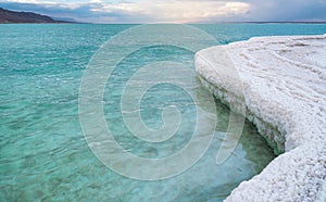 White salt crystals, clear cyan green calm water near, typical landscape at Ein Bokek beach, Israel