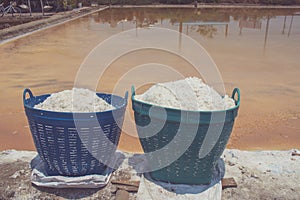 White salt in plastic basket for water evaporation place on edge of salt lake at countryside of Thailand.