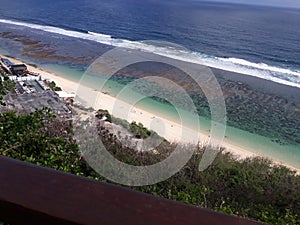 The white sand of Bali's Melasti Beach seen from the top of the hill overlooking the open ocean