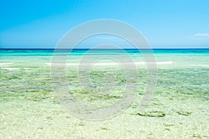 White sand beach and clear sea water under blue sky