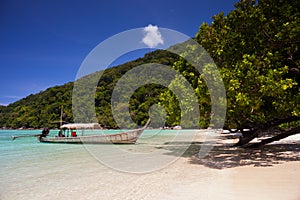 White sand beach with longboat at ocean in Tropicana country under clear sky