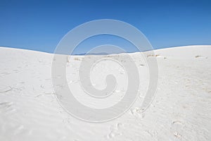 White sand, grass and blue sky