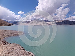 White Sand Lake with its sand dunes & teal colored waters by the Karakoram Highway, Pamir plateau, Xinjiang Autonomous Region