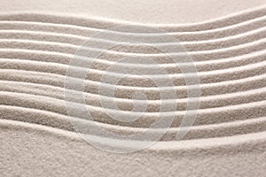 White sand with pattern as background, closeup. Concept of zen and harmony