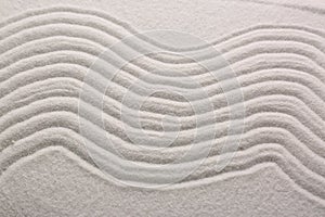 White sand with pattern as background, closeup. Concept of zen and harmony