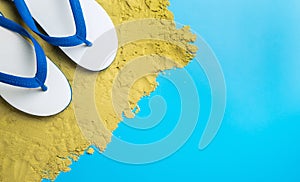 White Sandals on brown sand on blue